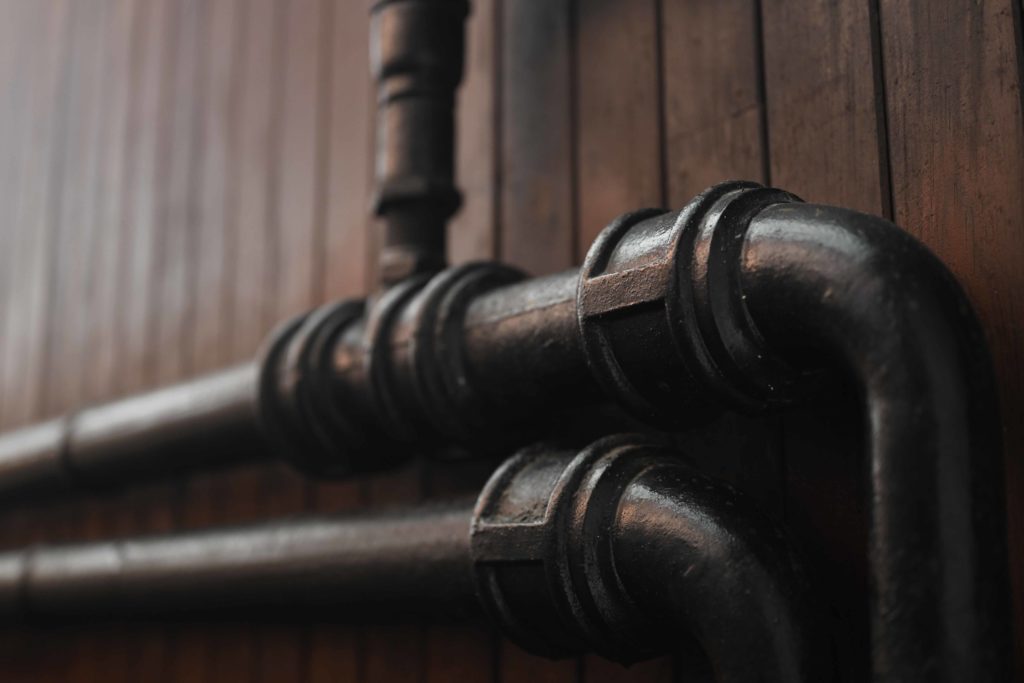 Close-up of the existing 50-year-old heavy cast-iron heating pipework inside Wainsgate Chapel.